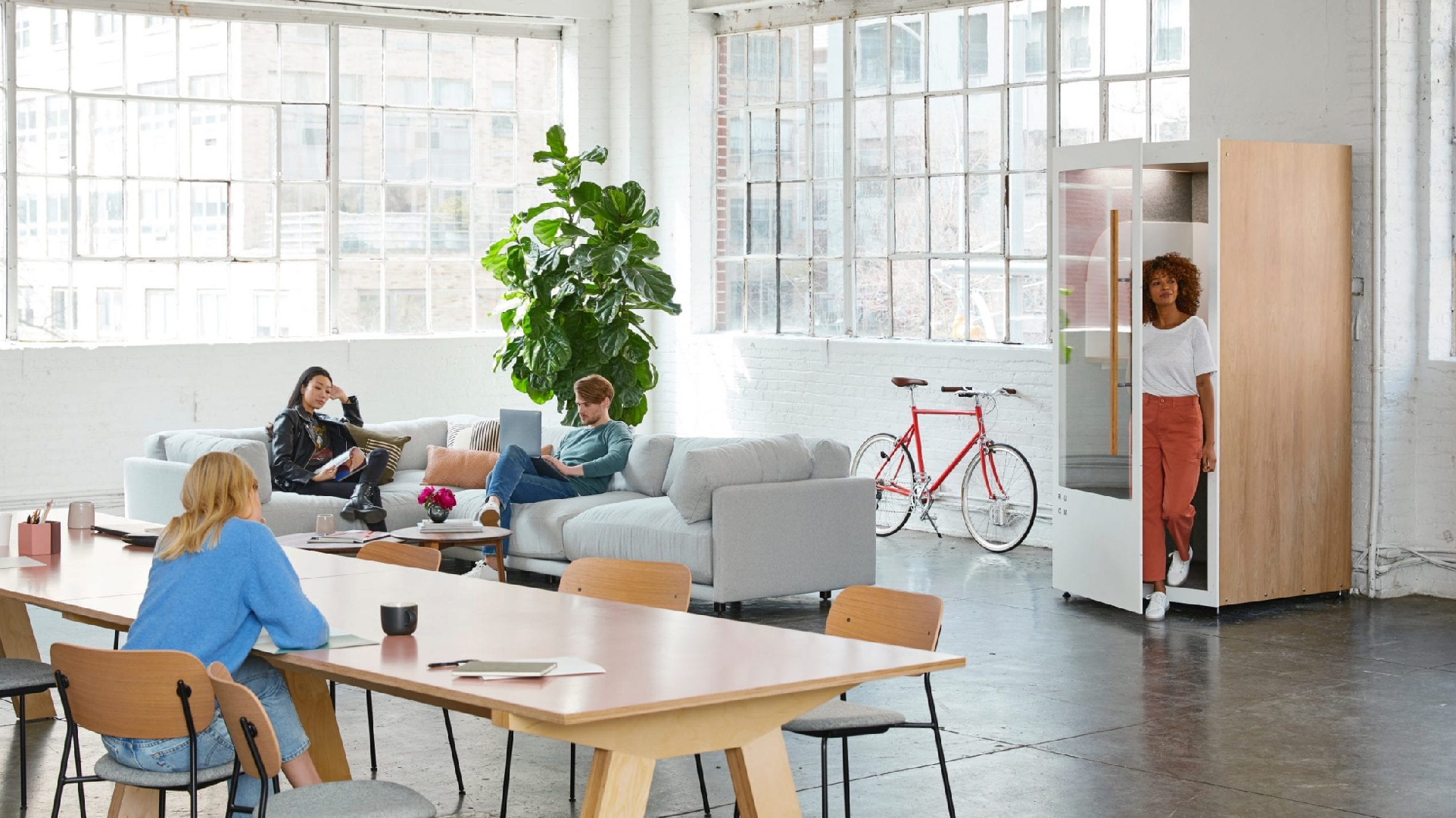 Four people using a shared workspace